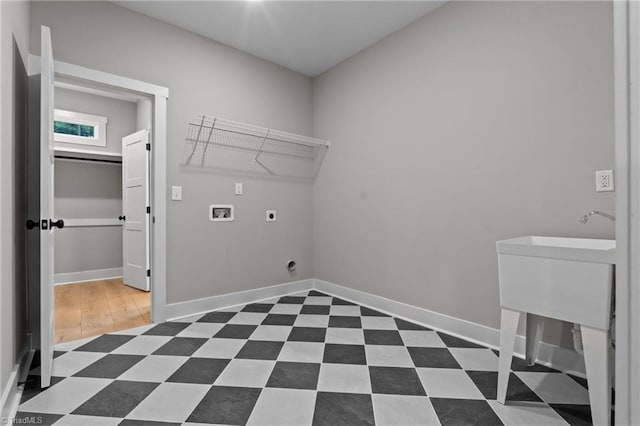 clothes washing area featuring dark floors, hookup for a washing machine, electric dryer hookup, laundry area, and baseboards