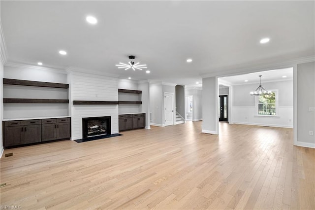 unfurnished living room with a fireplace, light wood finished floors, crown molding, and recessed lighting