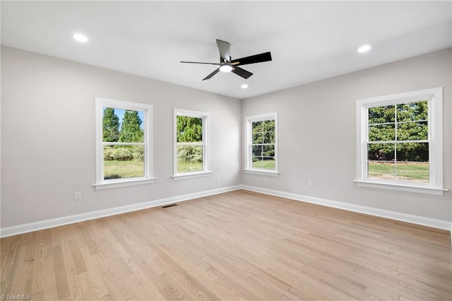 unfurnished room with visible vents, baseboards, light wood finished floors, and ceiling fan