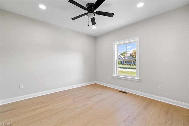 unfurnished room featuring light wood-style floors, visible vents, baseboards, and ceiling fan