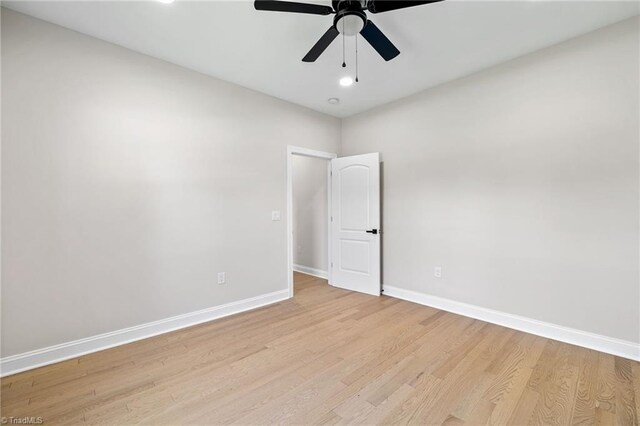 unfurnished room featuring baseboards, a ceiling fan, and light wood-style flooring