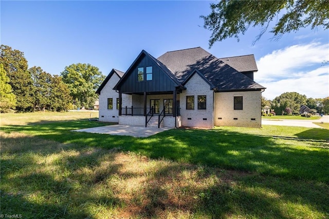 rear view of property featuring board and batten siding, a lawn, a porch, and crawl space