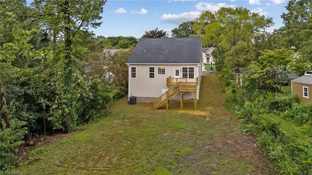 rear view of house with stairway, a deck, central AC, and a yard