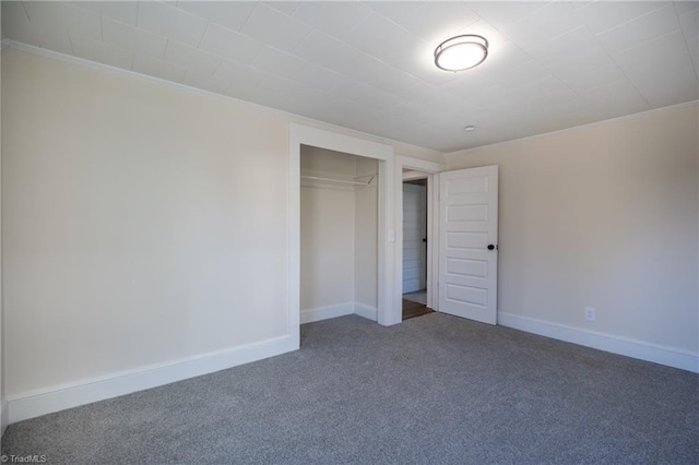 unfurnished bedroom featuring dark colored carpet and a closet