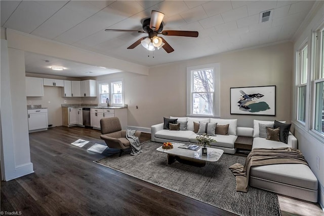 living room with crown molding, dark wood-type flooring, sink, and ceiling fan