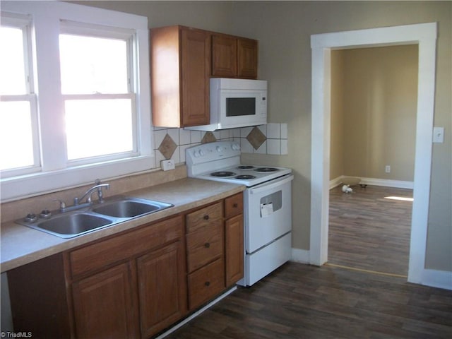 kitchen with decorative backsplash, sink, dark hardwood / wood-style floors, and white appliances