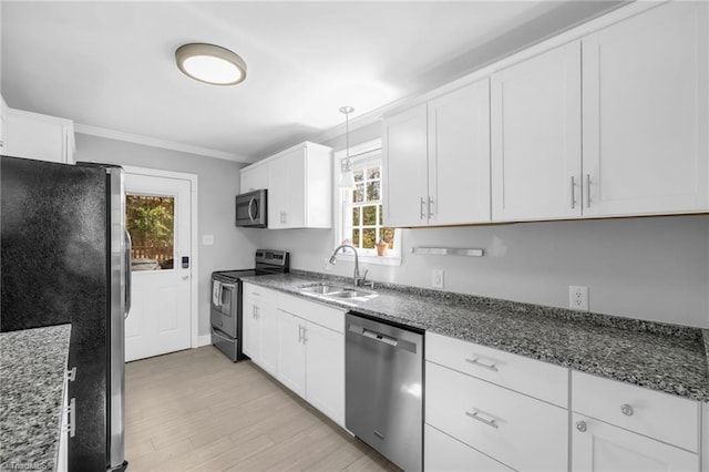 kitchen with a sink, light wood-style flooring, appliances with stainless steel finishes, and white cabinets