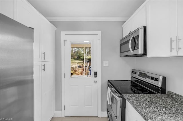 kitchen featuring dark stone countertops, baseboards, stainless steel appliances, white cabinetry, and crown molding