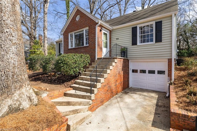 view of front of home featuring an attached garage, brick siding, and driveway