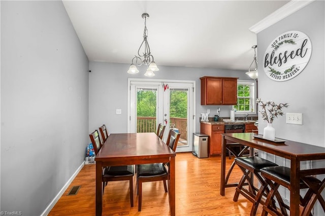 dining area featuring baseboards, visible vents, and light wood finished floors