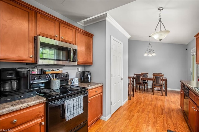 kitchen featuring black appliances, a notable chandelier, light wood-style flooring, and brown cabinets