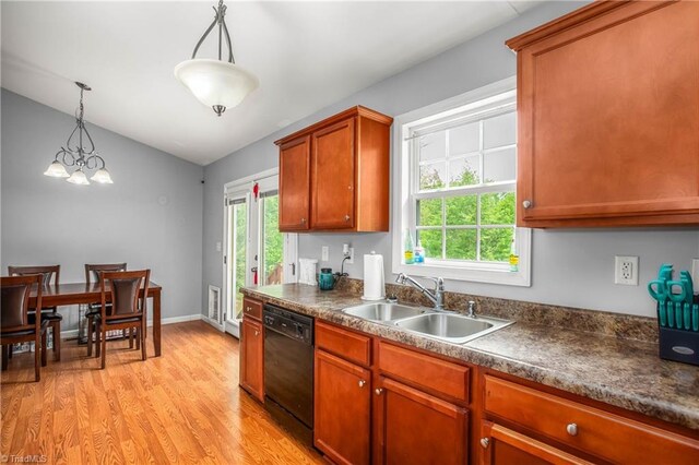 kitchen featuring light wood-style floors, dark countertops, dishwasher, a sink, and lofted ceiling