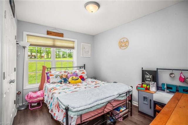 bedroom featuring wood finished floors and baseboards
