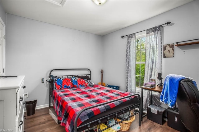 bedroom with baseboards and wood finished floors