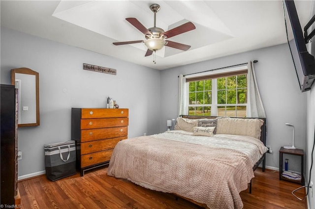 bedroom featuring baseboards, wood finished floors, and ceiling fan