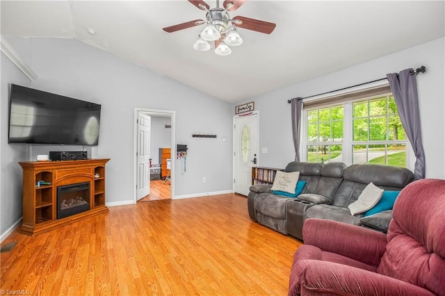 living room featuring light wood-style floors, baseboards, visible vents, a ceiling fan, and lofted ceiling