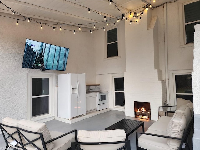 view of patio / terrace with an outdoor living space with a fireplace and area for grilling