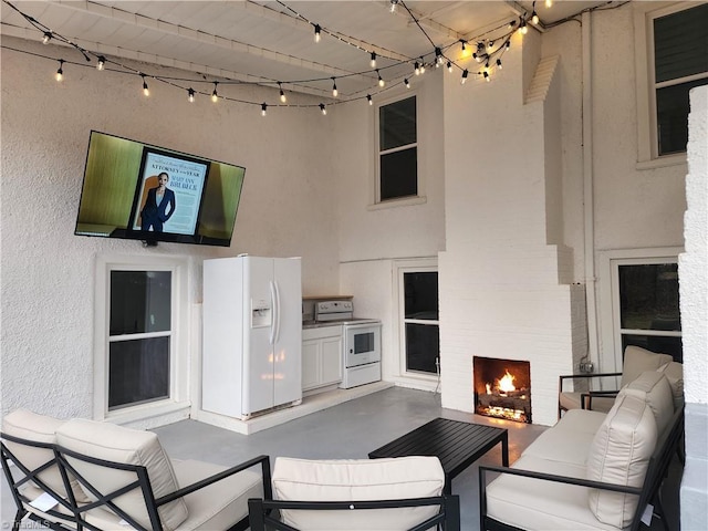 view of patio / terrace with an outdoor living space with a fireplace and area for grilling