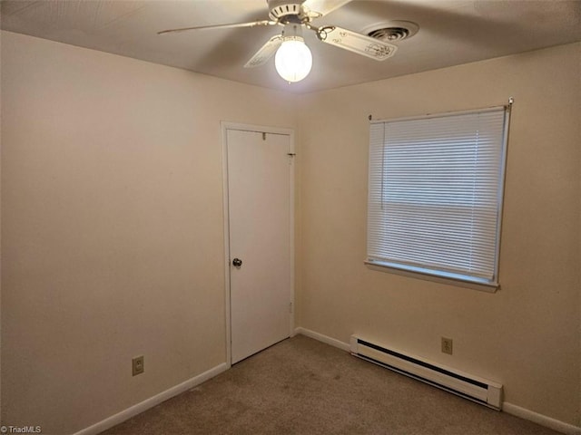 carpeted spare room featuring a baseboard heating unit and ceiling fan