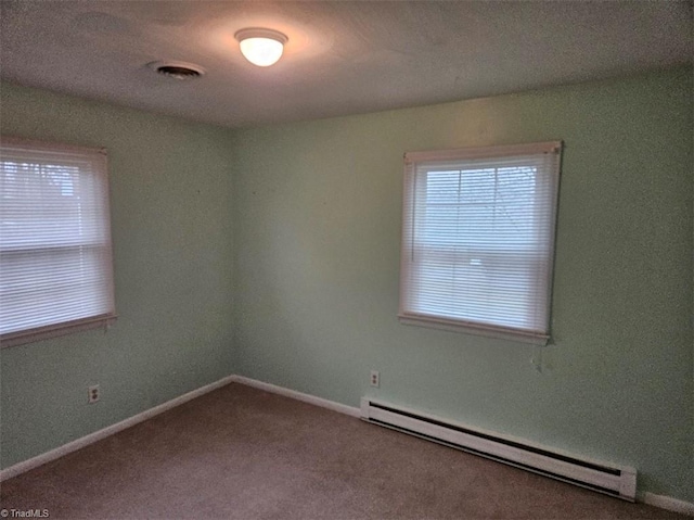 carpeted spare room with a baseboard radiator