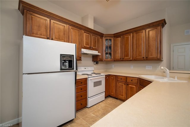 3913 Katie Dr, Greensboro, NC 27410 - kitchen with a sink, glass insert cabinets, white appliances, brown cabinetry, and under cabinet range hood
