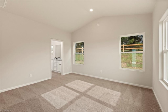 carpeted spare room featuring lofted ceiling