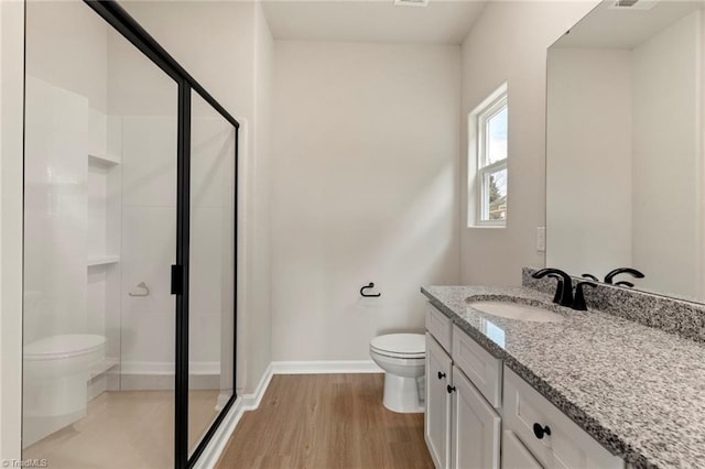 bathroom with wood-type flooring, vanity, toilet, and a shower with door