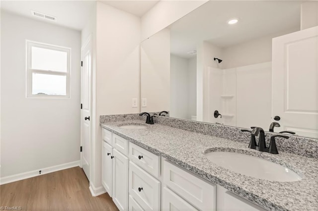 bathroom featuring vanity, wood-type flooring, and walk in shower