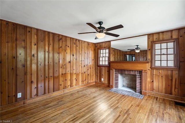 506 W 26th St, Winston-Salem, NC 27105 - unfurnished living room with hardwood / wood-style flooring, a brick fireplace, a ceiling fan, and wood walls