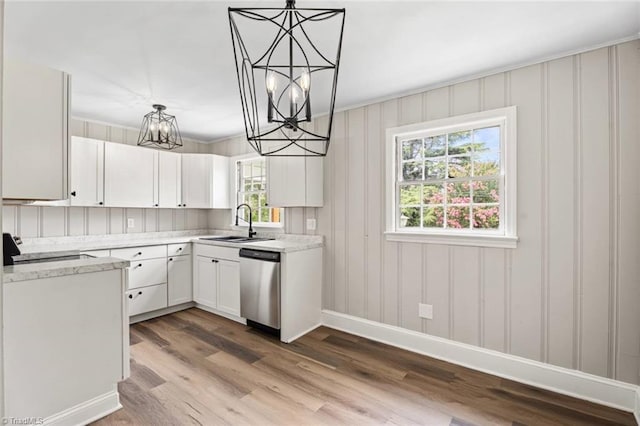 506 W 26th St, Winston-Salem, NC 27105 - kitchen featuring stainless steel dishwasher, a chandelier, wood finished floors, white cabinetry, and pendant lighting