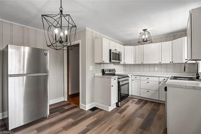 506 W 26th St, Winston-Salem, NC 27105 - kitchen with stainless steel appliances, a chandelier, dark wood-style floors, decorative light fixtures, and white cabinets