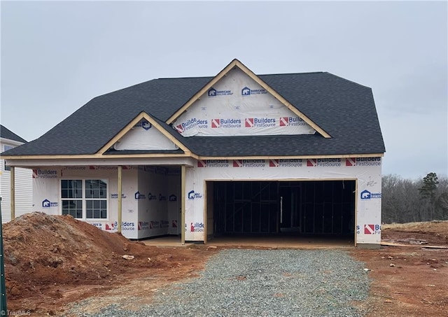 unfinished property featuring gravel driveway and a shingled roof