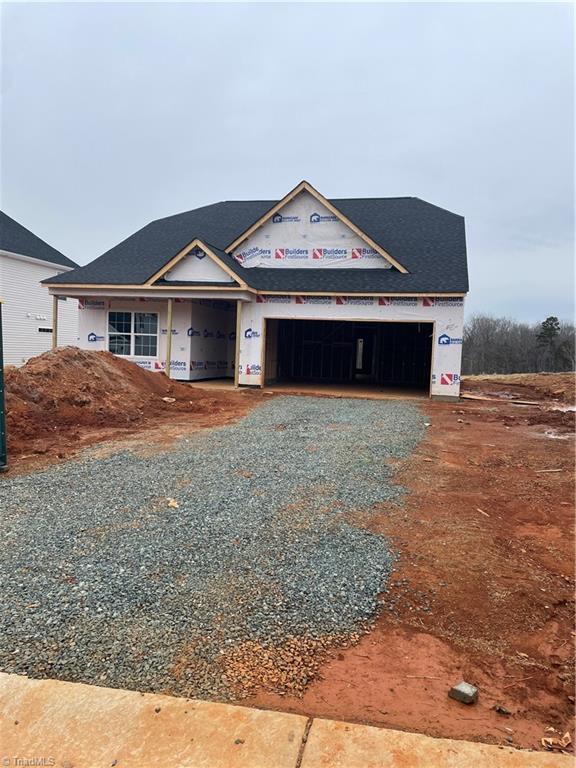 property in mid-construction featuring gravel driveway and a garage