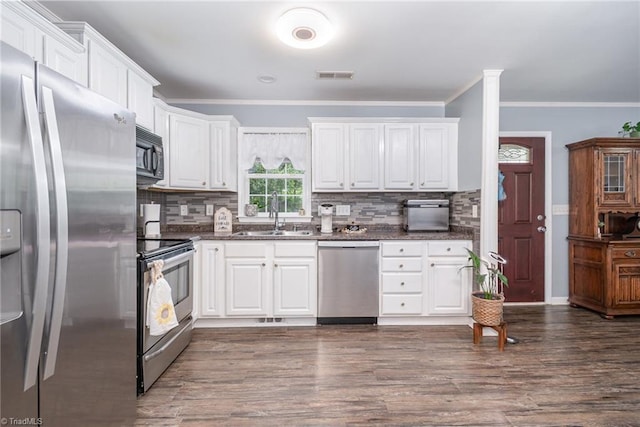 1029 Robbins St, Asheboro, NC 27203 - kitchen with stainless steel appliances, ornamental molding, decorative backsplash, and white cabinetry
