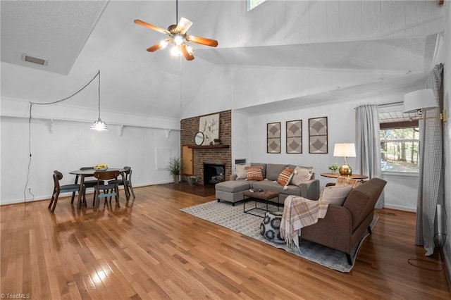 4701 Brock Dr, Hurdle Mills, NC 27541 - living area featuring ceiling fan, light wood finished floors, a fireplace, baseboards, and high vaulted ceiling