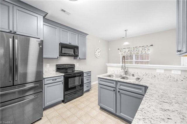 kitchen featuring gray cabinets, visible vents, hanging light fixtures, a sink, and black appliances