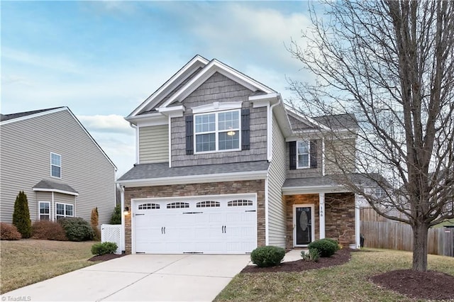 craftsman-style house featuring a garage, fence, concrete driveway, and a front yard