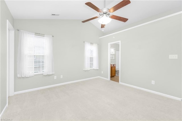 unfurnished room featuring lofted ceiling, light carpet, a ceiling fan, visible vents, and baseboards