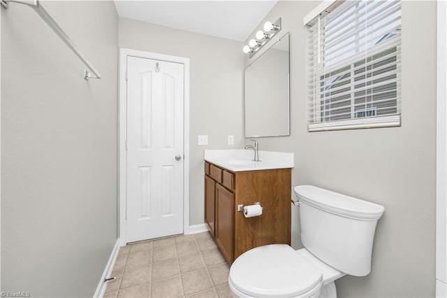 bathroom with toilet, tile patterned flooring, baseboards, and vanity