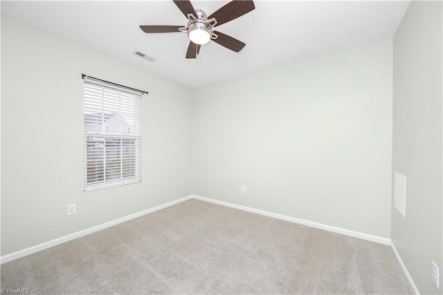 empty room with light colored carpet, visible vents, ceiling fan, and baseboards