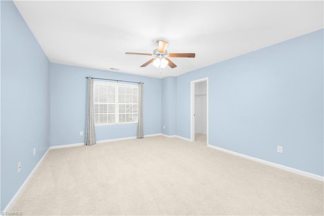 empty room with light carpet, baseboards, and a ceiling fan