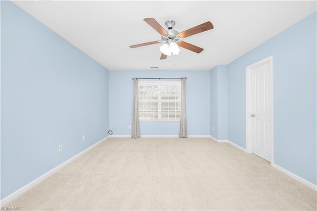 empty room with a ceiling fan, light colored carpet, and baseboards