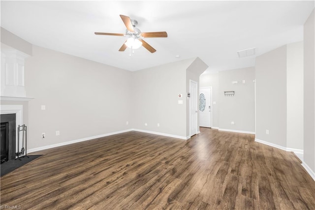 unfurnished living room with a fireplace with flush hearth, baseboards, ceiling fan, and dark wood-style flooring