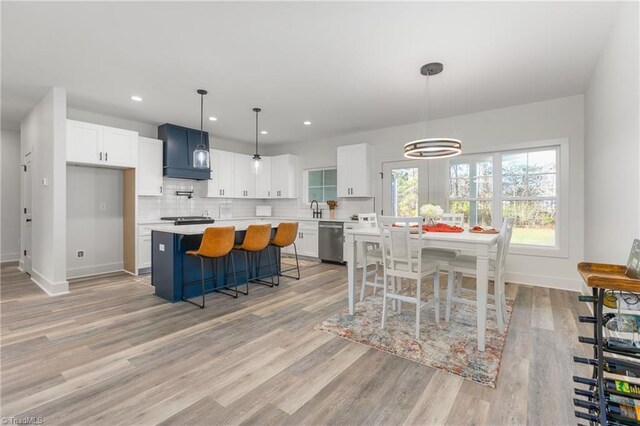 dining room featuring light wood-type flooring, an inviting chandelier, and sink