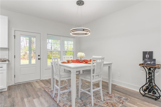 dining area featuring light hardwood / wood-style flooring and an inviting chandelier