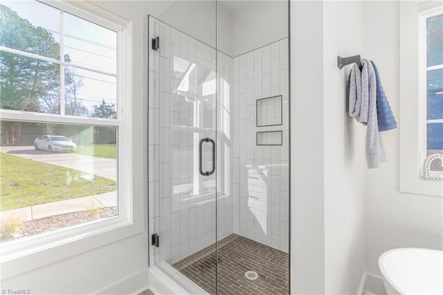 bathroom featuring plus walk in shower and a healthy amount of sunlight