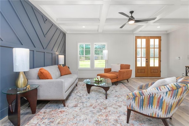 living room featuring french doors, ornamental molding, coffered ceiling, beam ceiling, and light hardwood / wood-style floors