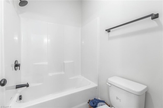 bathroom with bathing tub / shower combination and toilet