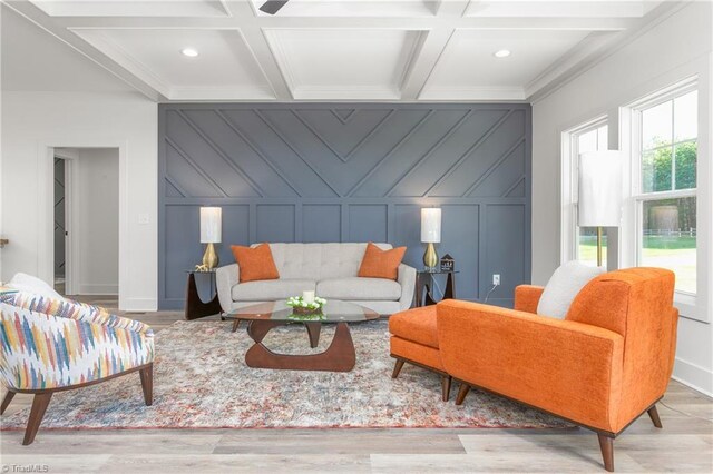 living room with beamed ceiling, light hardwood / wood-style floors, coffered ceiling, and ornamental molding