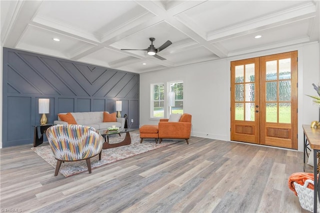 sitting room featuring french doors, beamed ceiling, light hardwood / wood-style floors, and coffered ceiling